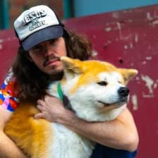 Thomas, founder of Slingshot, holding his Akita